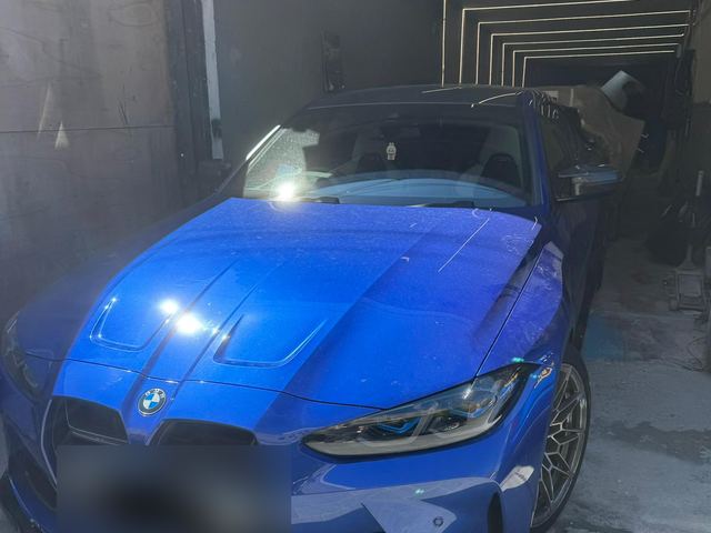 BMW M4 in the spray booth with front end rebuilt and resprayed
